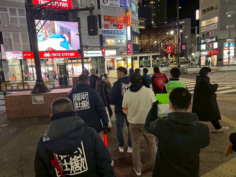 夜間の街頭で「社会を明るくする運動」の啓発活動を行う様子