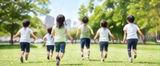 公園の芝生を走る子どもたち